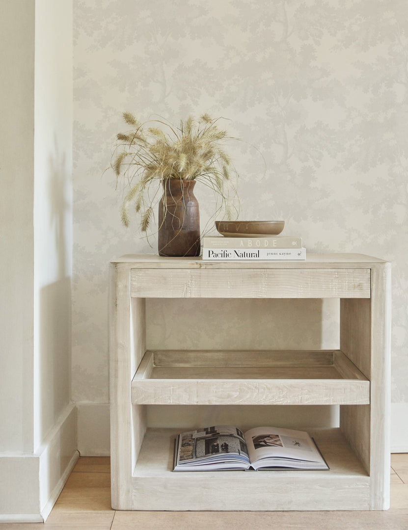 #color::white | The Scalamandre botanical inspired white raphael wallpaper is in a room with a whitewashed side table with books sitting atop it