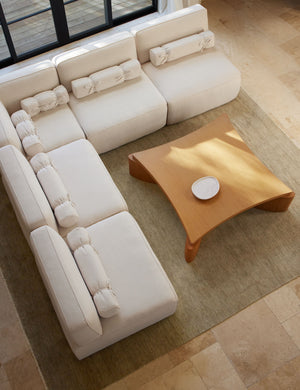 The Heritage moss gray rug lays in a living room under a square coffee table and an ivory sectional