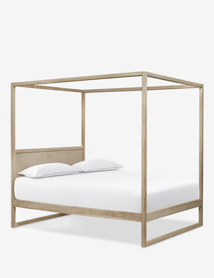Angled view of the Kiery light wood canopy bed