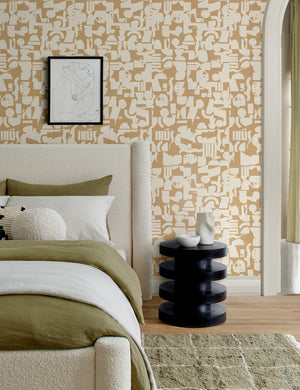 Ivory and taupe Organic Shapes Wallpaper by Sarah Sherman Samuel is in a bedroom with a boucle framed bed, a khaki green area rug, and a black nightstand