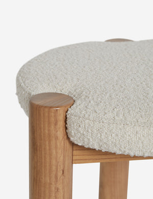 Close up of where the cream boucle cushion and leg intersect on the Kittredge compact stool