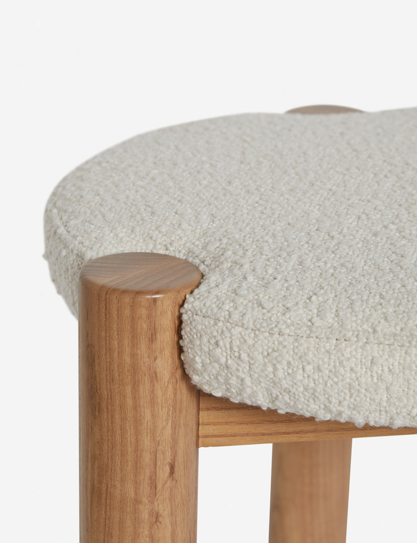 | Close up of where the cream boucle cushion and leg intersect on the Kittredge compact stool