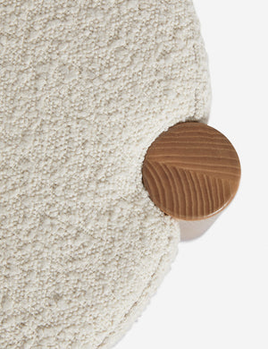Bird's-eye view of where the cream boucle cushion and leg intersect on the Kittredge compact stool