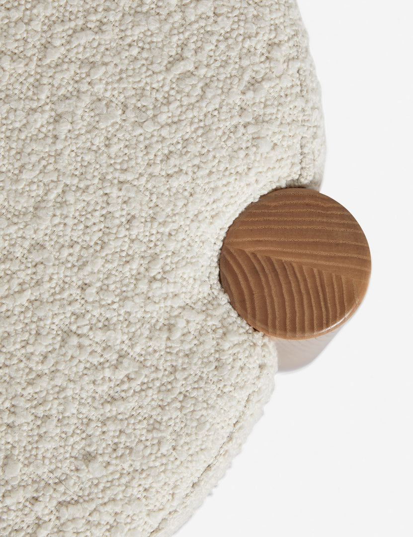 | Bird's-eye view of where the cream boucle cushion and leg intersect on the Kittredge compact stool