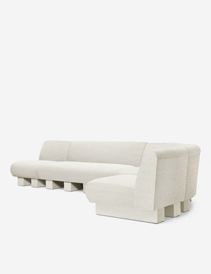 Angled view of the Lena right-facing natural linen sectional sofa with upholstered beam legs.