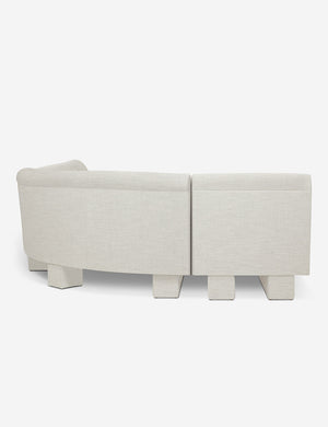 Rear view of the side of the Lena right-facing natural linen sectional sofa with upholstered beam legs.