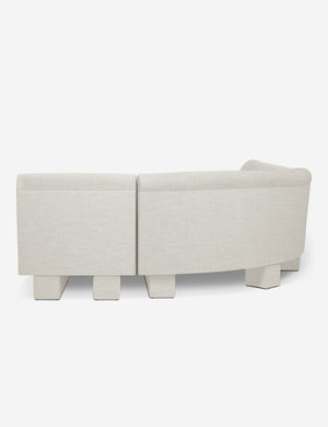 Rear view of the side of the Lena natural linen velvet sectional sofa with upholstered beam legs.