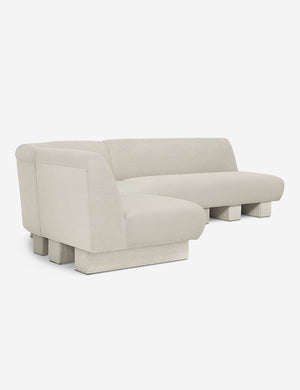 Angled view of the Lena left-facing white boucle sectional sofa with upholstered beam legs.