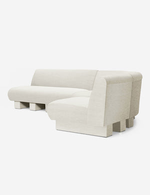 Angled view of the Lena right-facing natural linen sectional sofa with upholstered beam legs.