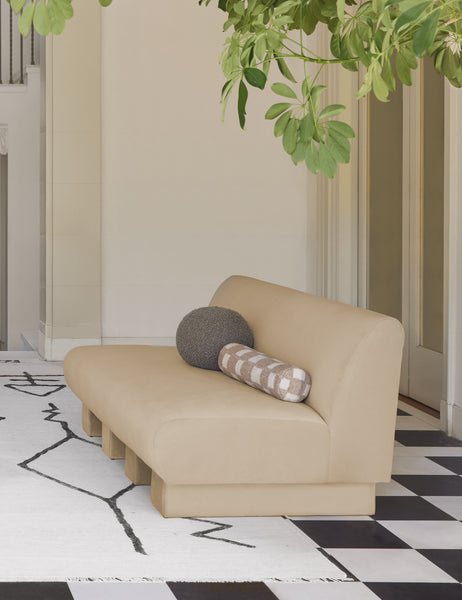 #color::khaki | Khaki gray Bouclé Ball Pillow by Sarah Sherman Samuel sits on a neutral armless sofa atop a black and white checkerboard floor
