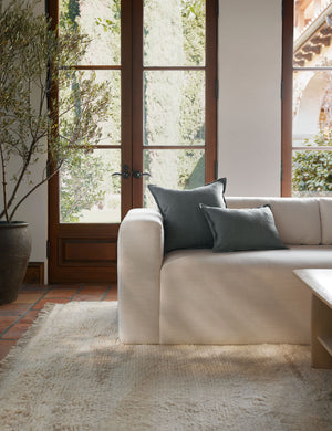 The arlo Dusty Blue flax linen pillow in its lumber and square sizes sit together on a natural linen sofa