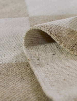 The Palau beige rug folded over itself