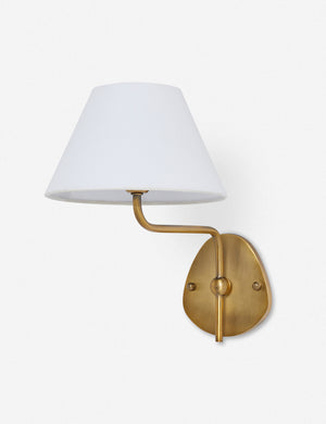 Magdalene brass single sconce with a white linen shade, a round wall mount, and an arched arm
