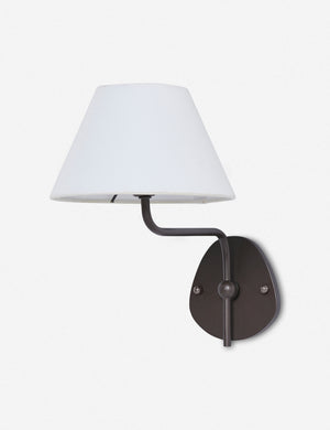 Magdalene black single sconce with a white linen shade, a round wall mount, and an arched arm