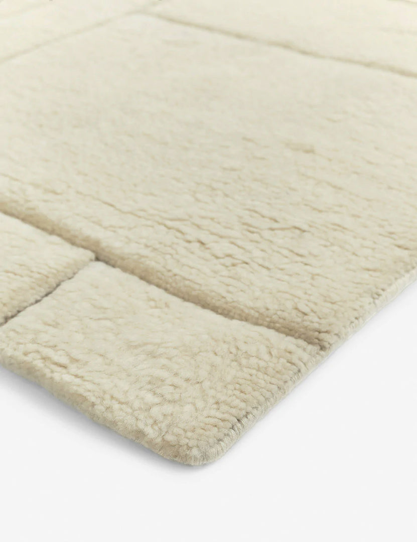 #size::6--x-9- #size::8--x-10- #size::9--x-12- #size::10--x-14- #size::12--x-15- | The corner of the Maleena cream hand-knotted wool and cotton area rug with abstract line tufting