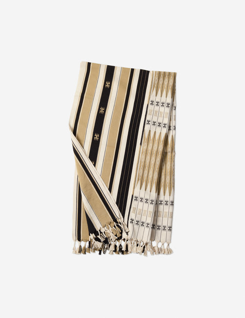| Sita black, natural, and ivory throw blanket that is loin-loomed with indigenous motifs and fringe at the ends