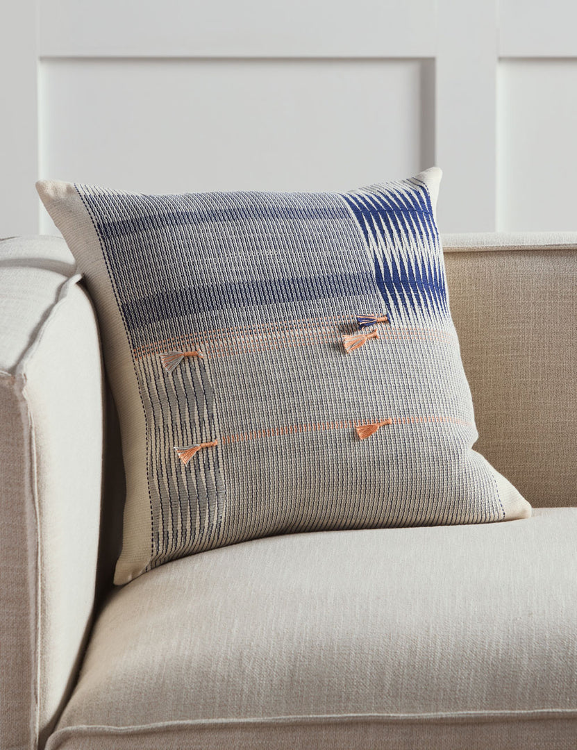 #color::blue #size::18--x-18- #insert::down #insert::polyester | The Narola artisan ivory square throw pillow sits on a natural linen sofa in a room with accented white walls