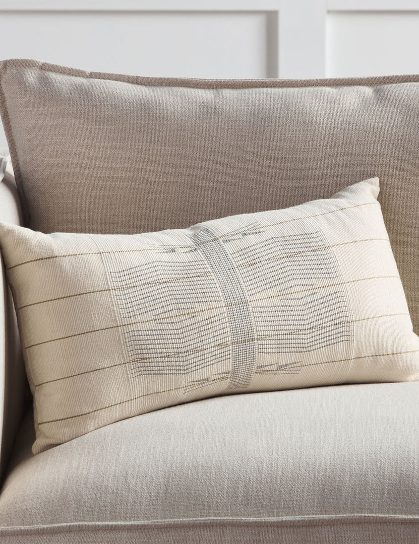 #color::gray #fill::down #fill::polyester | The Imli ivory and gray throw pillow sits on a gray linen sofa in a room with accented white walls