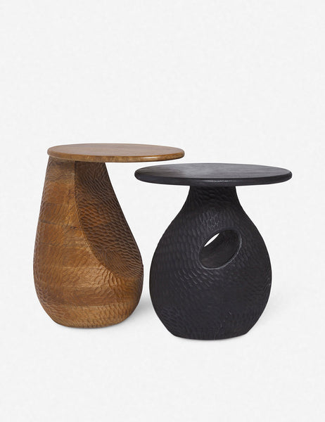 | The Gem mango wood side table is nested over a black side table with a similar design