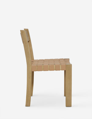 Side view of the Vix light wood frame and woven leather seat dining chair.