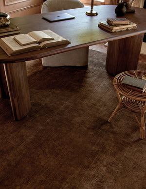 The Chiltern copper rug lays in an office space with wooden accented walls under a dark wooden desk