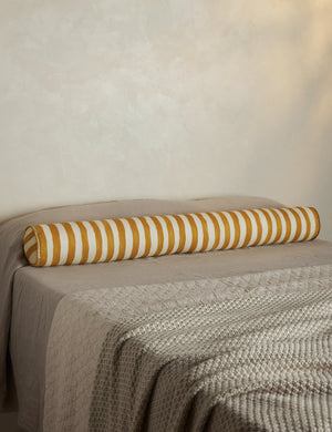 Painterly stripe linen long bolster throw pillow in goldenrod and ivory styled on a bed
