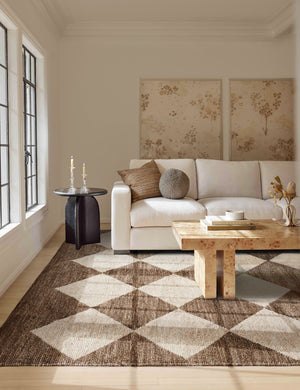 The Palau brown rug lays in a living room under a burl wood coffee table and a white sofa