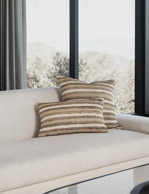 Thora silk earth-toned striped pillow in its lumbar and square sizes sit together on an ivory linen sofa