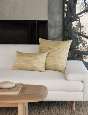 The leni silk pillow in both sizes sit together on a white linen sofa next to a wooden coffee table
