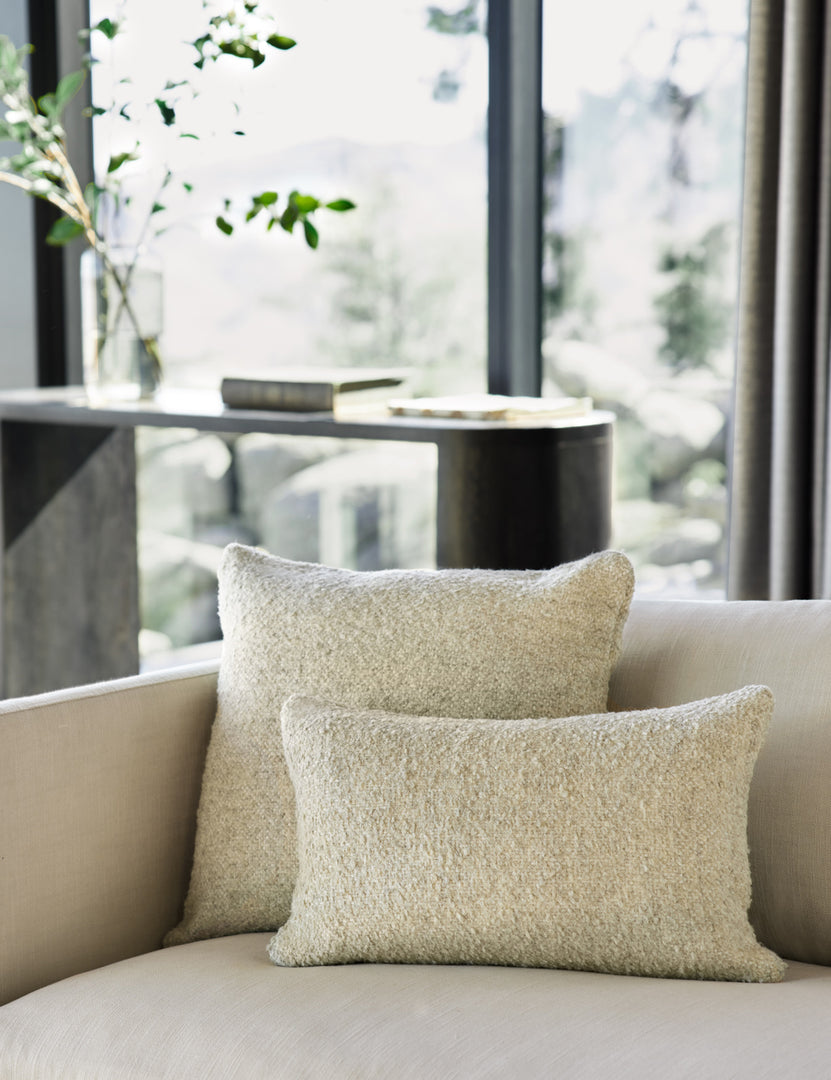 #color::oatmeal #size::20--x-20- | The manon linen oatmeal cream boucle pillow in both sizes lay on a white linen sofa in a living room with a black wooden sideboard 