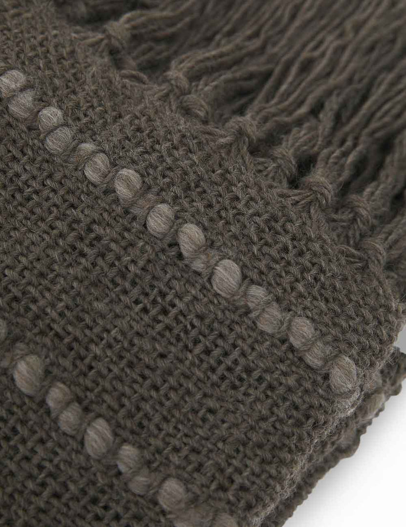 | Detailed shot of the light gray detailing in the Pismo dark gray pure wool throw blanket with fringed ends