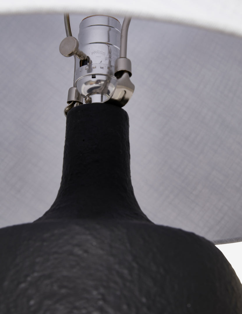 #color::black | The silver hardware and light switch on the inside of the Pratt black table lamp