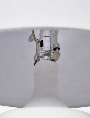 The silver hardware and light switch on the inside of the Pratt white table lamp