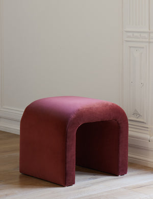 Angled view of the Paprika Velvet Tate Stool in front of a white accented wall