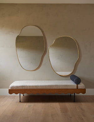 Both sizes of the puddle mirror hang together above a Sarah Sherman Samuel daybed with an ivory cushion and blue pillow