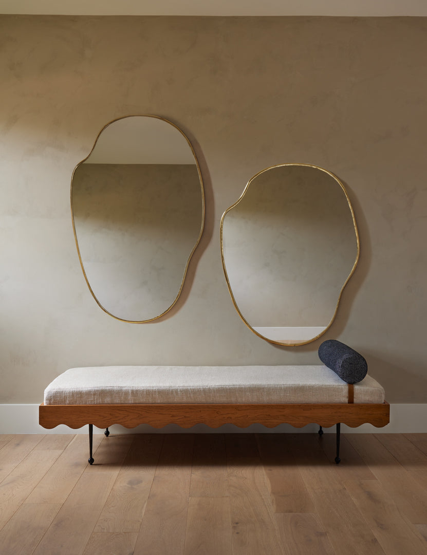 | The Rise Day bed sits in a room with neutral-toned walls under two brass-framed Sarah Sherman Samuel mirrors