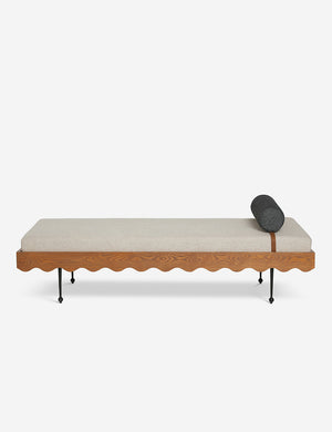 Rise daybed with a cream upholstered cushion, scalloped wood detailing, and spindle legs by Sarah Sherman Samuel