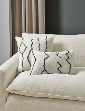 The Moroccan black and natural beni ourain inspired square and lumbar flat weave pillow by Sarah Sherman Samuel sit together on a cream linen sofa