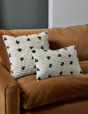 Irregular Dots Pillow by Sarah Sherman Samuel in its lumbar and square sizes sit on a cognac velvet couch