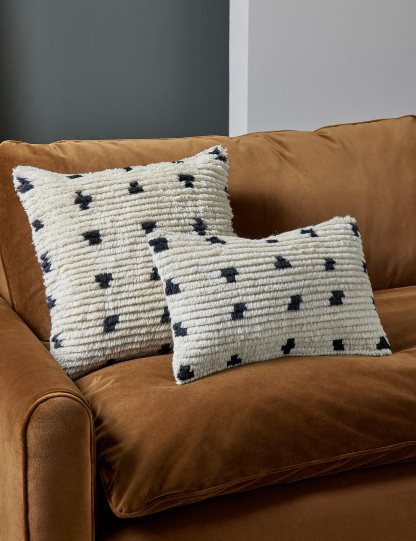#style::lumbar #style::square | Irregular Dots Pillow by Sarah Sherman Samuel in its lumbar and square sizes sit on a cognac velvet couch
