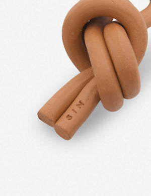 Close up of the Overhand terracotta ceramic Knot decorative object by SIN