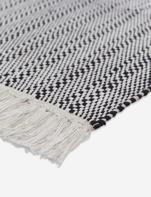 Close-up of the thick fringe on the Saskia handwoven high contrast black-and-white patterned mat