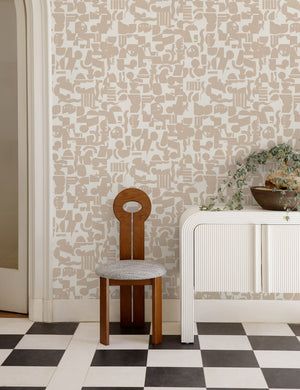 Ivory and taupe Organic Shapes Wallpaper by Sarah Sherman Samuel is in a room with a white console table, a sculptural dining chair, and black and white checkerboard floors