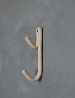 Cream speckled Leggy Long Wall Hook by SIN Ceramics hanging on a gray wall