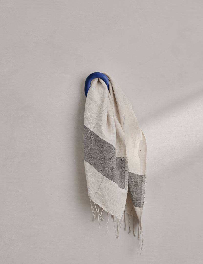 #color::cobalt-blue | The olo cobalt blue wall hook hangs on a wall with a towel