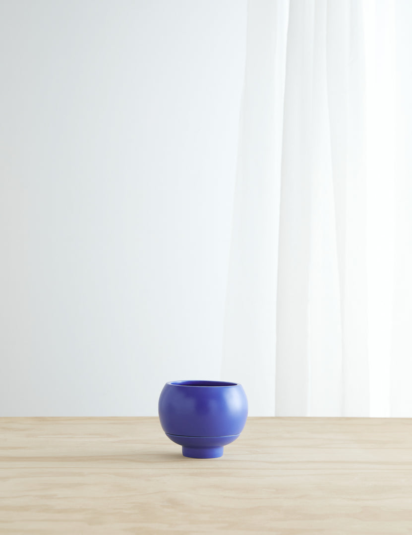 #color::cobalt | Sutton Ceramic Self-Watering Planter by Greenery Unlimited in cobalt blue sits on a wooden table