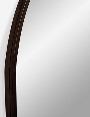 Detailed shot of the oil rubbed bronze metal frame on the Tulca curved standing mirror with flat bottom edge.