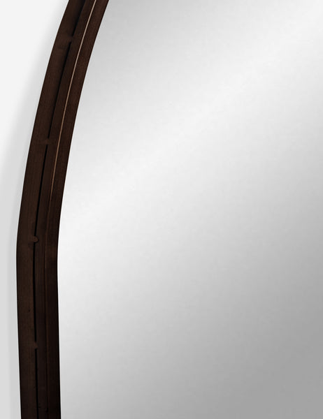 #color::oil-rubbed-bronze | Detailed shot of the oil rubbed bronze metal frame on the Tulca curved standing mirror with flat bottom edge.