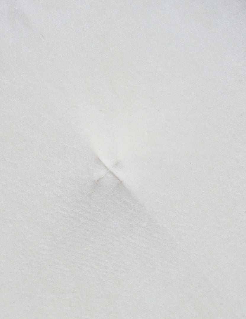 #color::ivory | Close up of the "X" stitch in the center of the velvet disc pillow by Sarah Sherman samuel