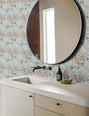 Dark-toned Floral Field Wallpaper by Rylee + Cru is in a bathroom with white countertops and a circular white framed mirror